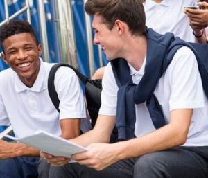 estudantes sorrindo em conversa no pátio da escola sobre projeto de vida