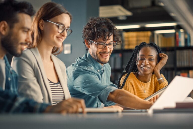 Dois homens e duas mulheres sentados, estudando juntos.