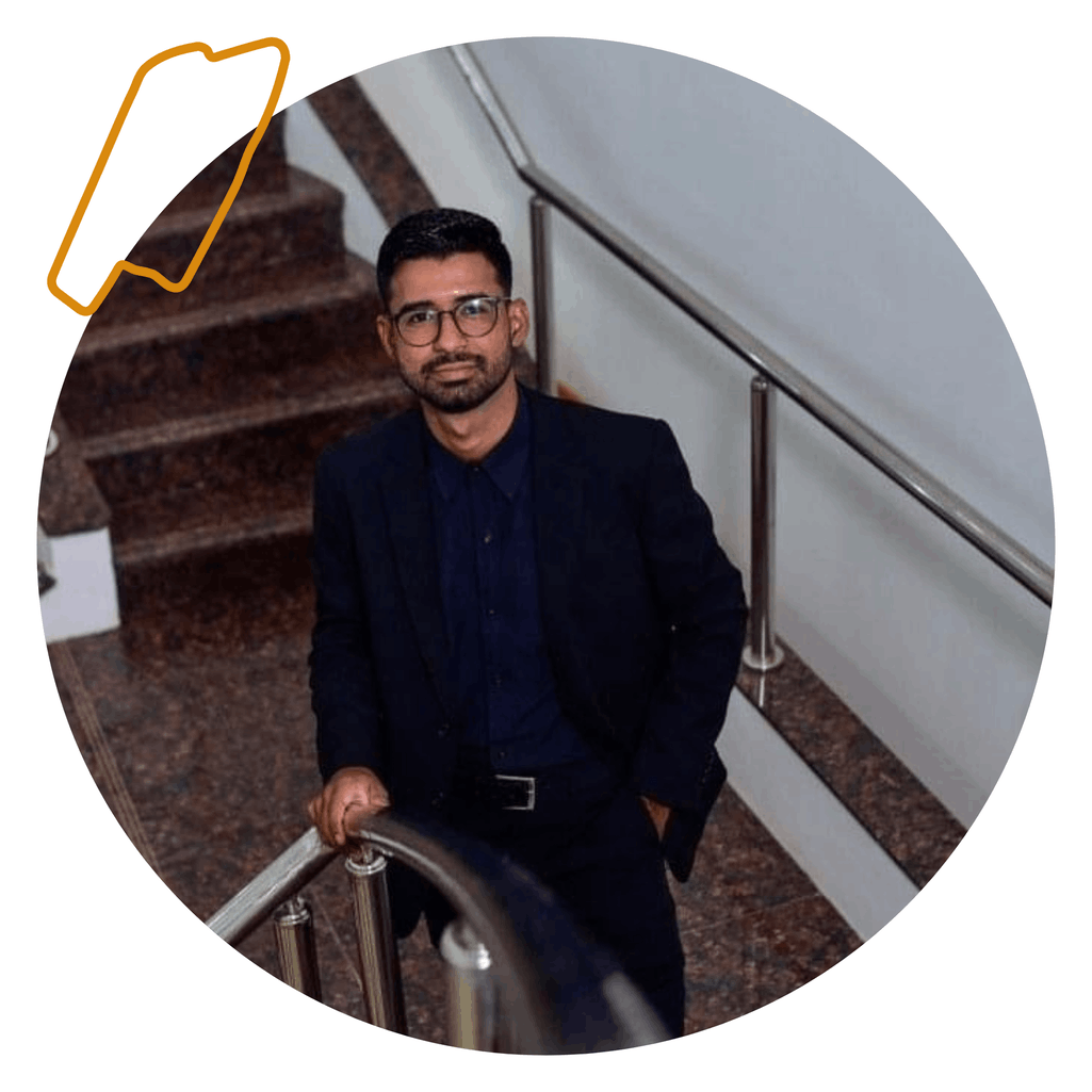 Lucas de terno preto, próximo a uma escadaria.