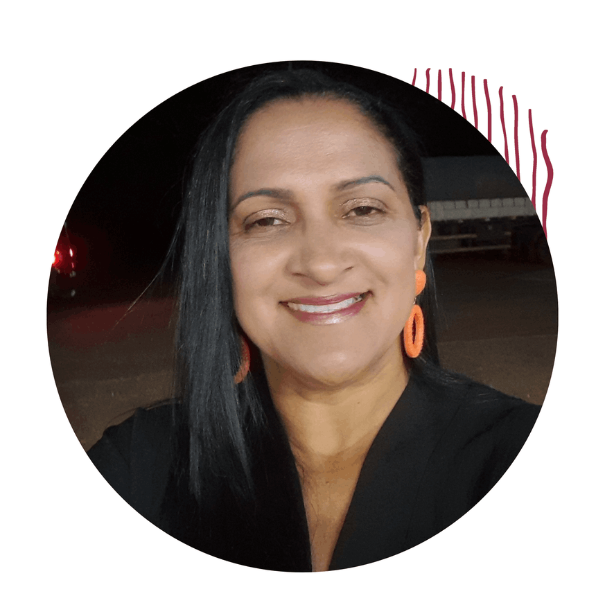 Mulher e blusa preta, brincos, cabelos soltos, sorrindo.