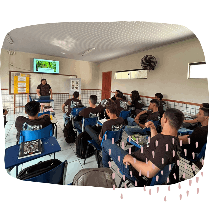 Estudantes na sala de aula, prestando atenção na professora.